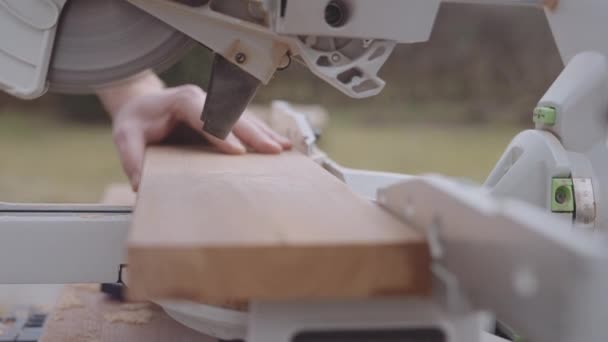 Stolarz za pomocą Mitre Saw do cięcia drewna — Wideo stockowe