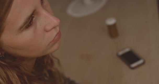 Depressieve vrouw zitten met pillen in de achtergrond — Stockvideo