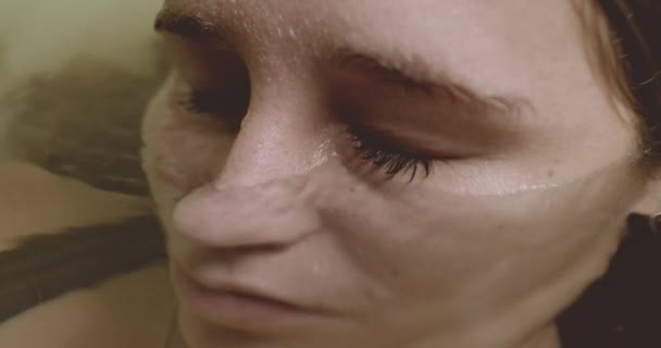 Žena zavírající oči pod vodou v koupelně — Stock video