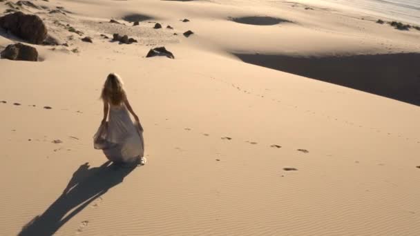 Беспилотник женщины, гуляющей по песчаному пляжу — стоковое видео