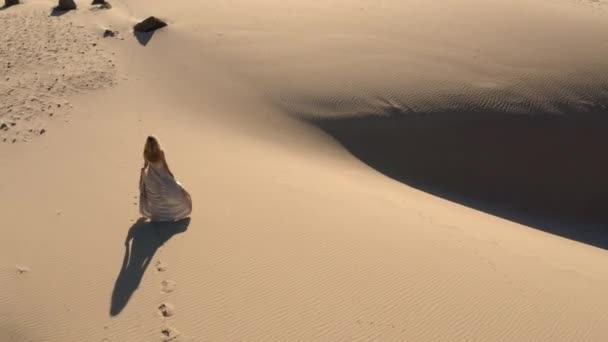 Беспилотник женщины в платье прогуливался по песчаному пляжу — стоковое видео