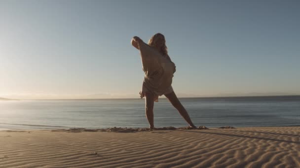 Bailarina elegante en vestido en la playa de arena soleada — Vídeos de Stock