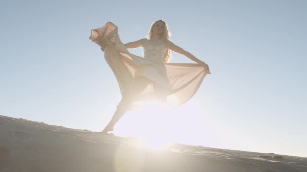 Schöne Frau in Gold tanzt vor der Sonne — Stockvideo