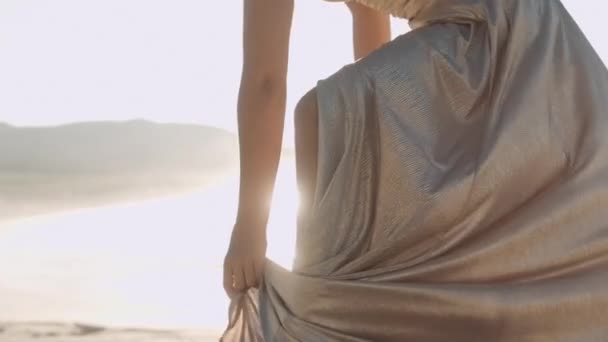 Krásná žena tanec ve zlatých šatech na pláži — Stock video