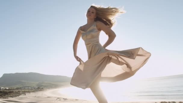 Tanzen blond frau im gold auf sunlit strand — Stockvideo