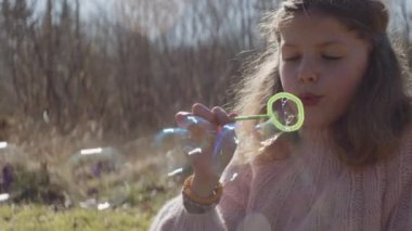 Baloncuk çıkaran kız ve onları kovalayan erkek kardeş.