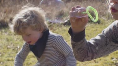Erkekler kabarcıklar çıkarıyor ve sahada oynuyorlar