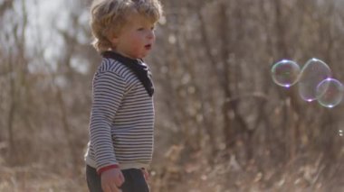 Onları kovalarken genç bir çocuğun etrafında kabarcıklar uçuşuyor.