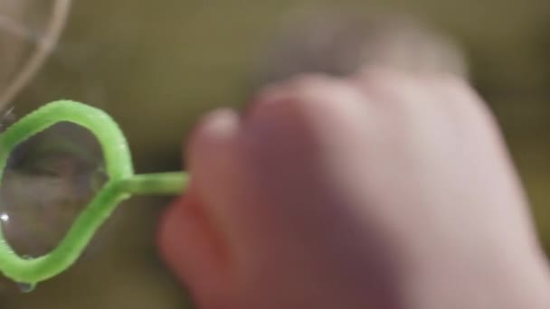 Junge bläst Blasen für seinen Bruder zum Platzen — Stockvideo