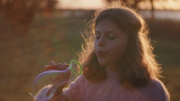 Young Girl Blowing Bubbles In Sunlight At Sunset — Stock Video