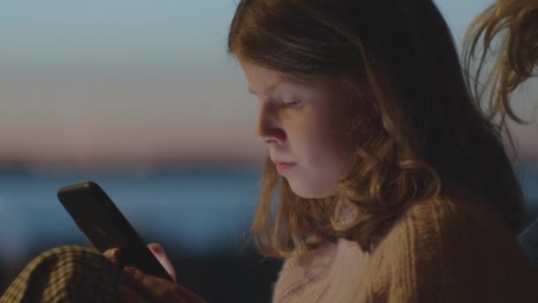 Сестра і брат грають на смартфонах в сутінках — стокове відео