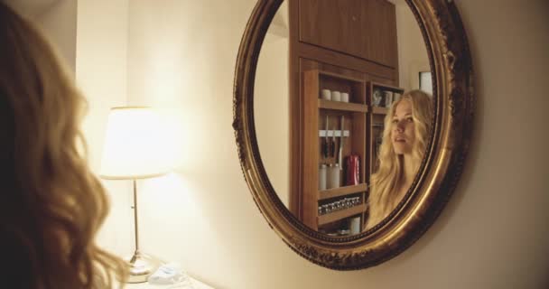 Jeune femme regardant son reflet dans le miroir — Video