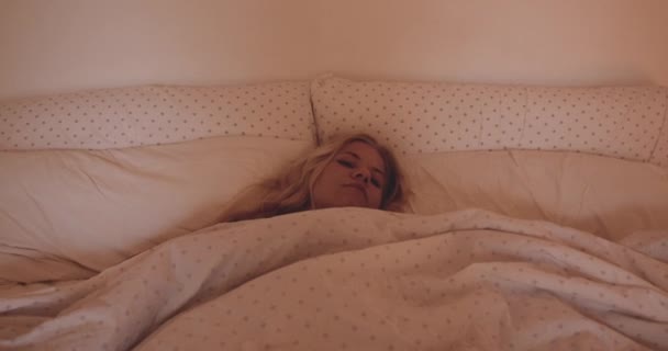 Жінка прокидається і сидить у ліжку — стокове відео