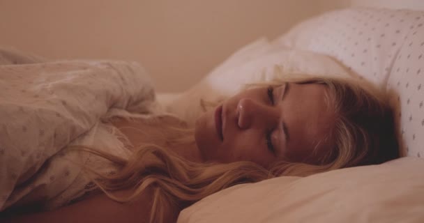 Mulher abrindo os olhos na cama e sentada — Vídeo de Stock