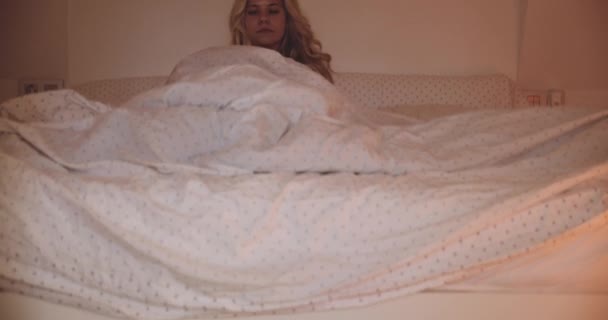 Wanita muda cantik keluar dari tempat tidur di pagi hari — Stok Video