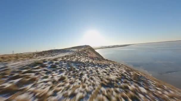 雪のパッチ、明るい空、穏やかな海- FPVドローンショット — ストック動画
