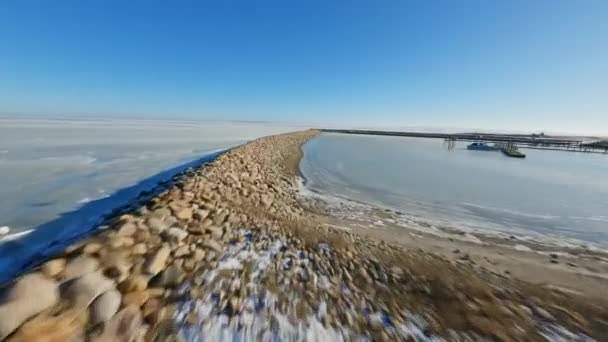 Tir de drone FPV surplombant la plage de la côte ouest avec des rochers près du terrain — Video