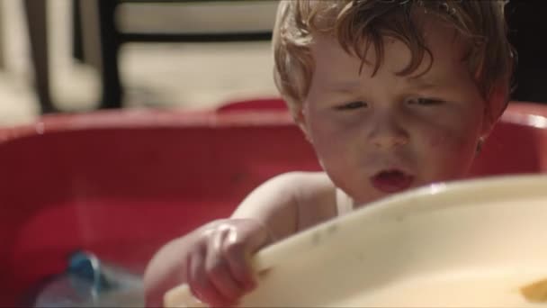 玩塑料玩具和泼水的男孩 — 图库视频影像