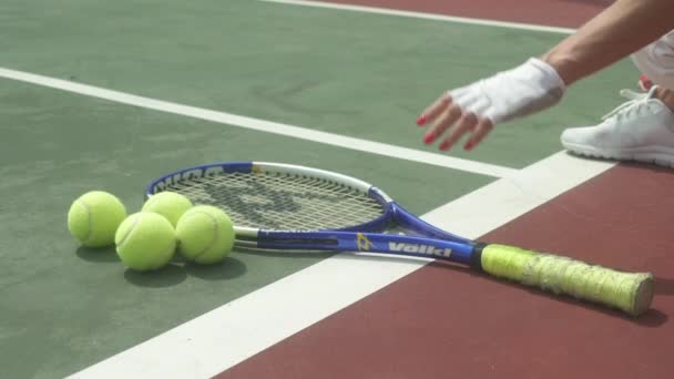 Colpo costante di donna che raggiunge per la palla da tennis e la racchetta a terra — Video Stock