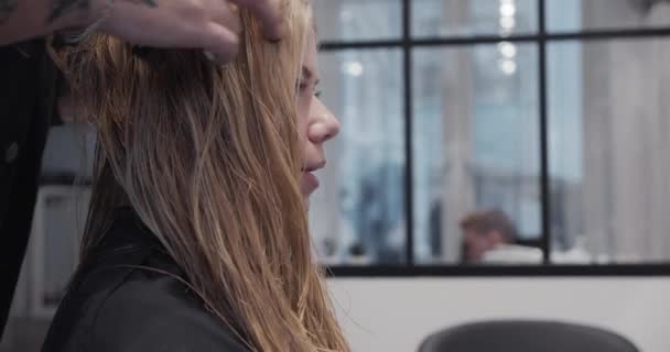 Κομμωτήριο Τακτοποιεί τα μαλλιά της νεαρής ξανθής γυναίκας — Αρχείο Βίντεο