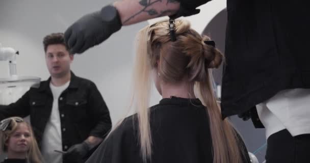 Парикмахерская в парикмахерской беседует с клиентом — стоковое видео