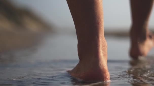 Man går barfota genom havsvatten på stranden — Stockvideo