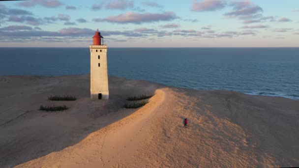 Vol de drone au-dessus de l'homme et du phare de Rubjerg Knude — Video