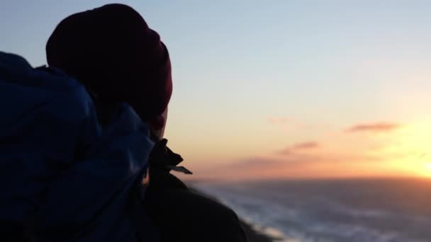 Wandelaar kijken zonsondergang vanaf het strand — Stockvideo