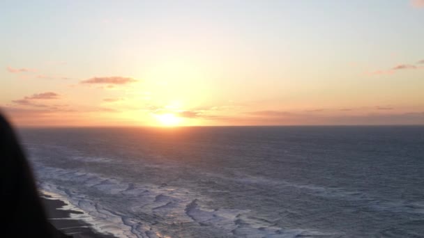 Vandrare tittar på solnedgång från stranden — Stockvideo