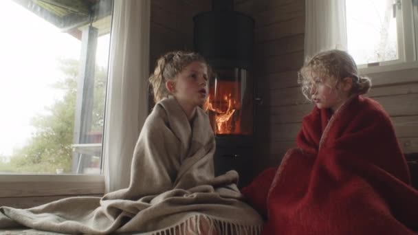 Młode dzieci w kocach przez ogień w domu — Wideo stockowe