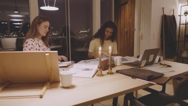 Жіночі студенти університету навчаються за столом за допомогою тонких свічок — стокове відео