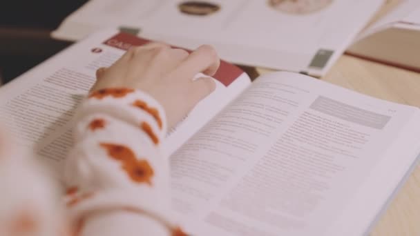 Universitetsstudentens hand när hon läser textbok — Stockvideo