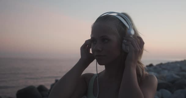 Woman Listening To Music By Sea At Sunset — Vídeos de Stock