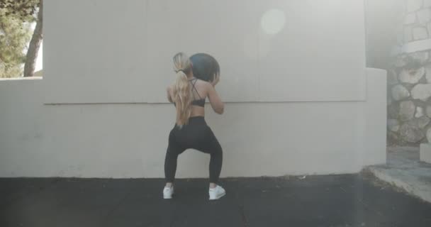 Young Woman Squatting To Throw And Catch Medicine Ball — 图库视频影像