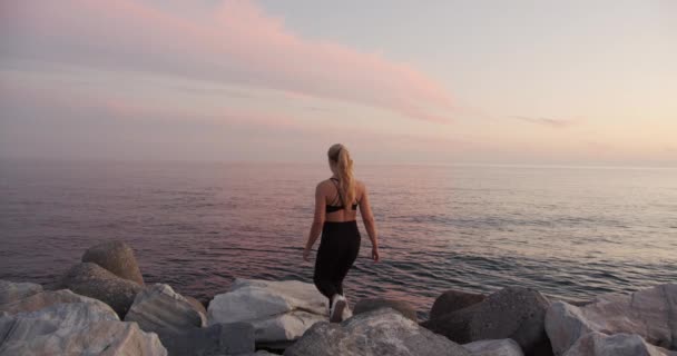 Young Athlete Watching Sunset Over Sea From Rocks — Vídeos de Stock