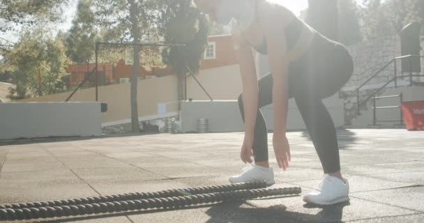 Ung kvinna som använder Battle Ropes i utomhus gym — Stockvideo