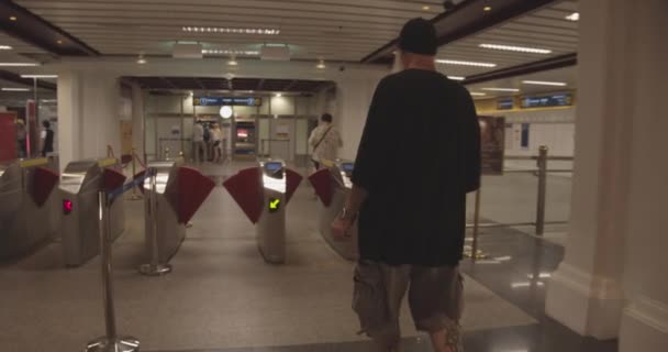 Seguindo o tiro do homem que caminha para a estação de trem bem-lit — Vídeo de Stock