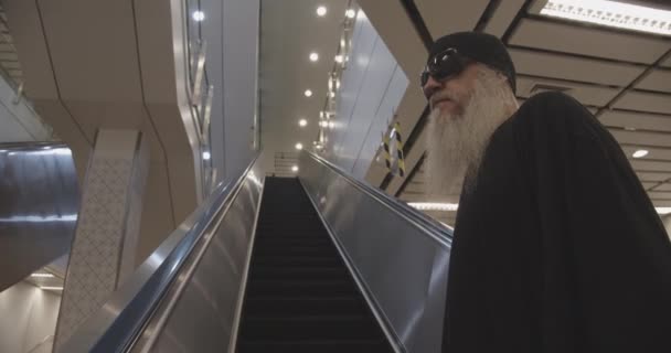Homme avec barbe et lunettes de soleil monter l'escalator — Video