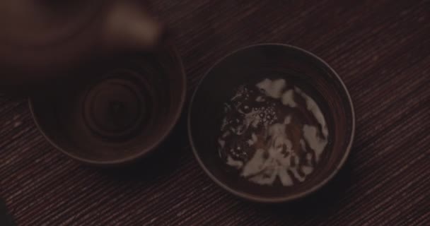 POV Shot of Man Verser du thé sur des tasses à thé traditionnelles en céramique — Video