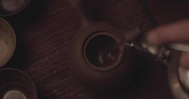 POV do homem derramando água quente sobre uma panela de chá lindamente artesanal — Vídeo de Stock