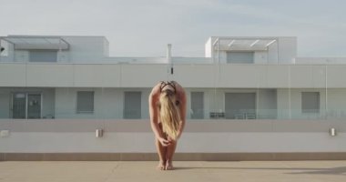 Dişi Yogini bir çatı katında poz veriyor.