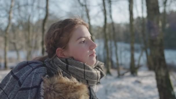 Jonge vrouw loopt het bos in terwijl de zon in haar gezicht straalt — Stockvideo