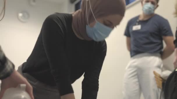 Frau im Hijab führt Brustkompressionen an einer Schaufensterpuppe durch — Stockvideo