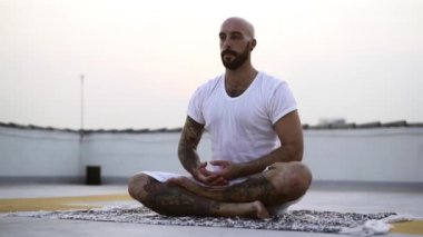 Meditasyon yaparken beyaz gömleğiyle terleyen beyefendi.