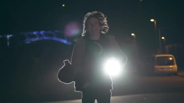 Joven modelo rastreado por un coche en una noche cubierta por el cielo nocturno — Vídeo de stock