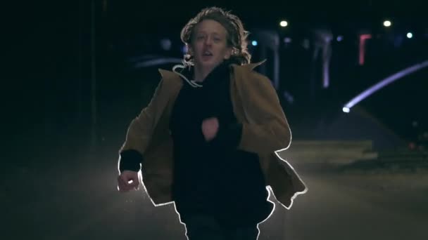 Hombre perseguido en una calle oscura con solo luces procedentes del coche — Vídeos de Stock
