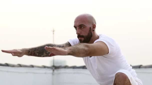 Homem executa a dose forte do Yoga com uma perna quando seus braços forem suspensos no ar — Vídeo de Stock