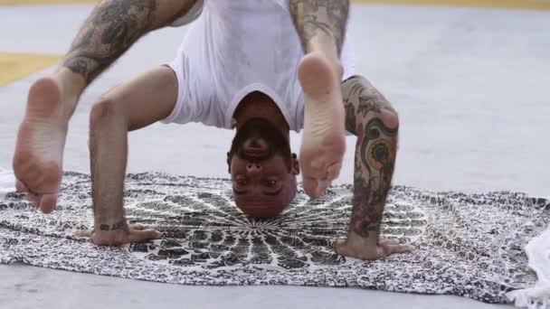 Yogi balanceert een headstand met zijn handen op de grond — Stockvideo