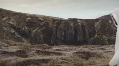 Beyaz bornoz giyen biri Dağ Çerçevesi 'ne girer.