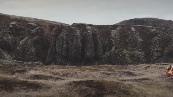 A Guy Walking In The Mountain Dragging A Red Sheer Fabric On The Ground — Stock Video